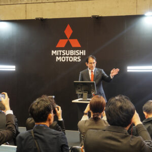 「新型クロスカントリーSUV」を予告する岸浦新社長の背景には新しい「パジェロの顔」」を匂わせるパネルが