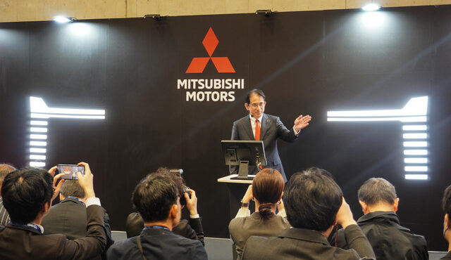 「新型クロスカントリーSUV」を予告する岸浦新社長の背景には新しい「パジェロの顔」を匂わせるパネルが